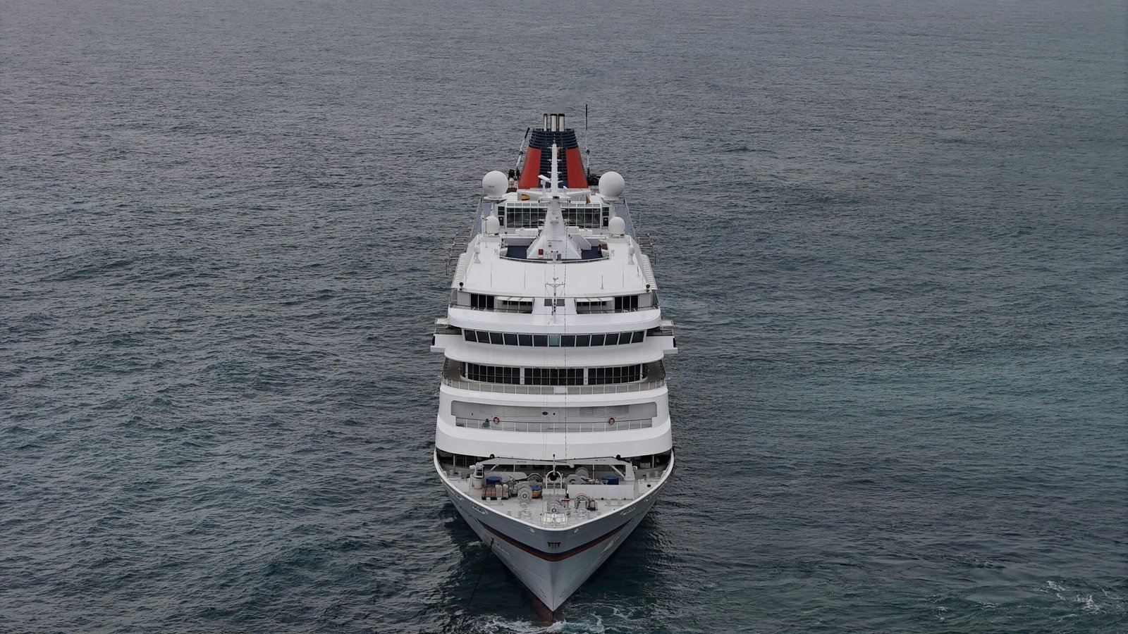 Aerial view of a luxurious cruise ship navigating the waters off Marbella, Spain, during sunset.