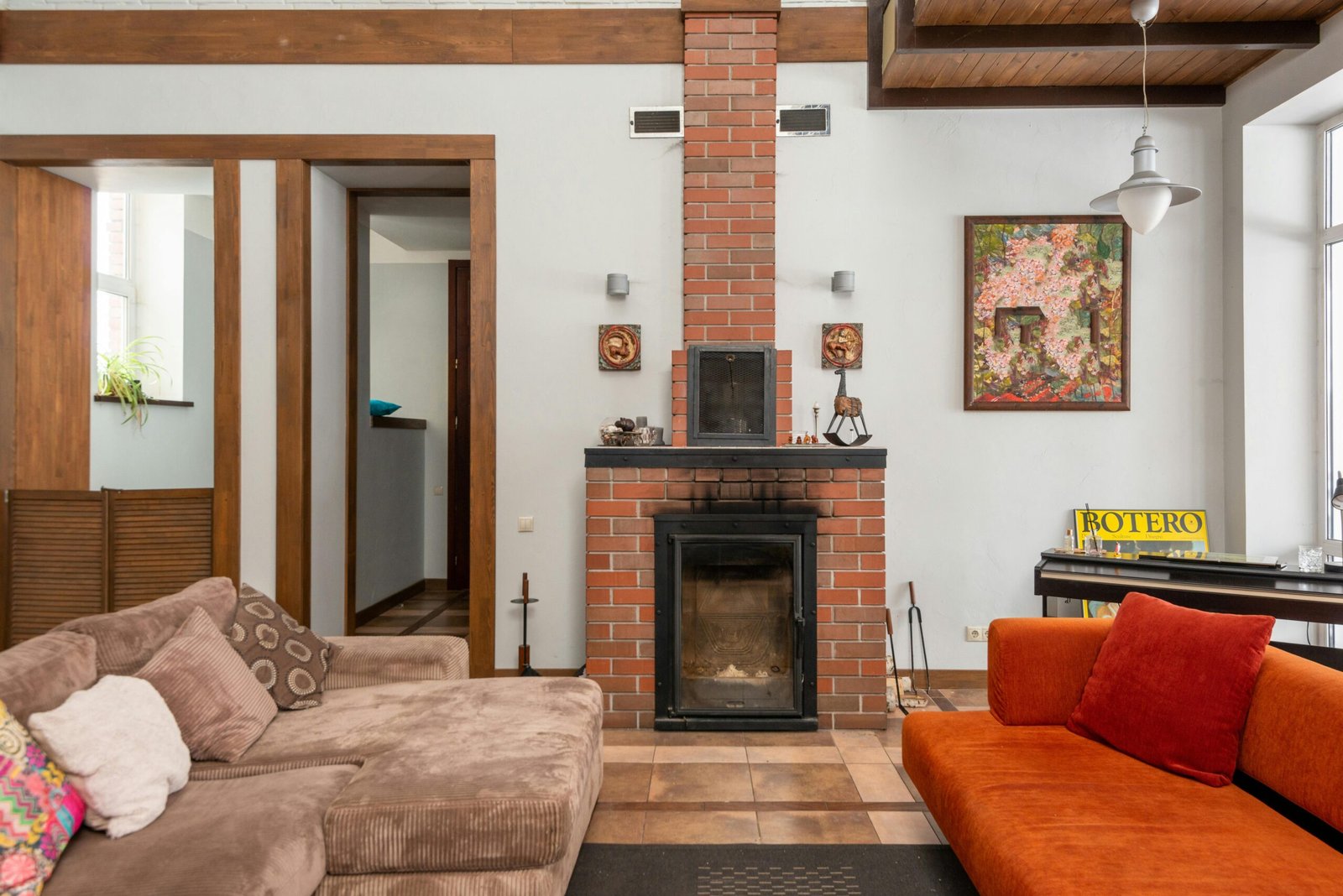 A cozy living room featuring a modern design with a brick fireplace and stylish decor.