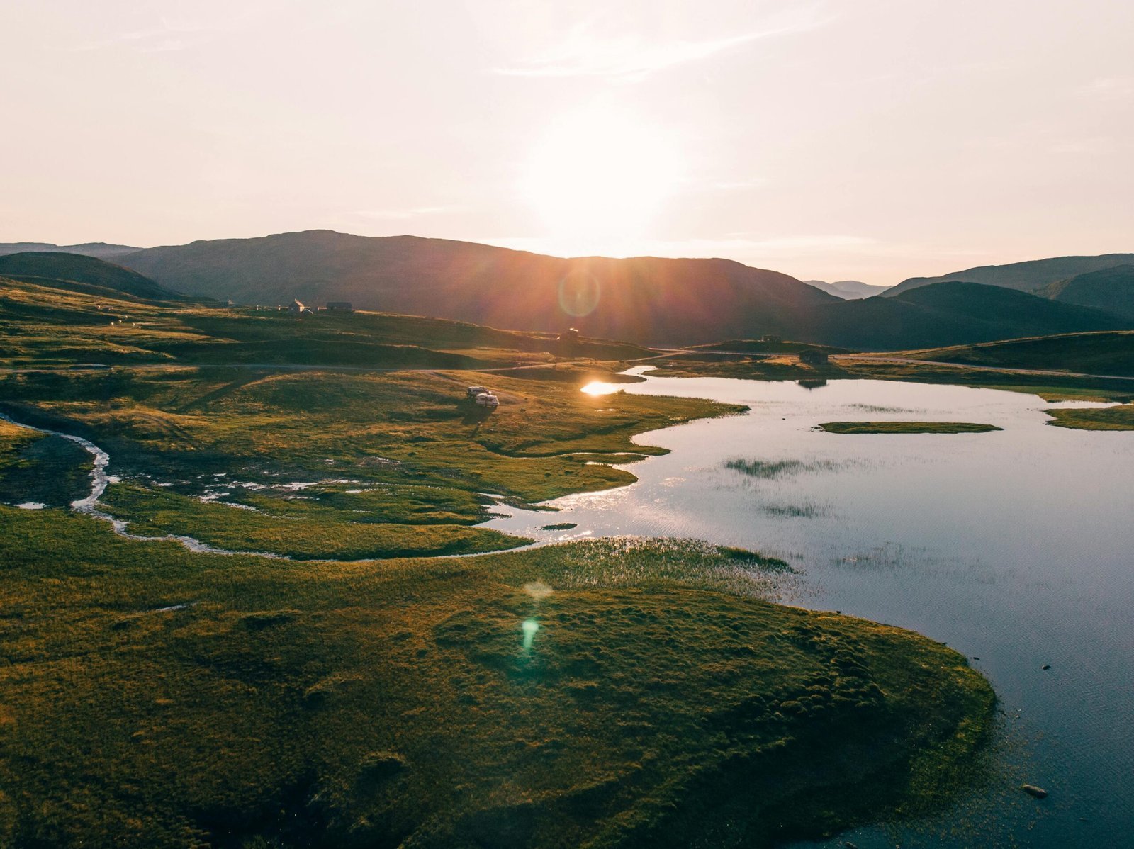 A peaceful sunrise over a Norwegian lake landscape with hills and reflections. Perfect for travel and nature enthusiasts.