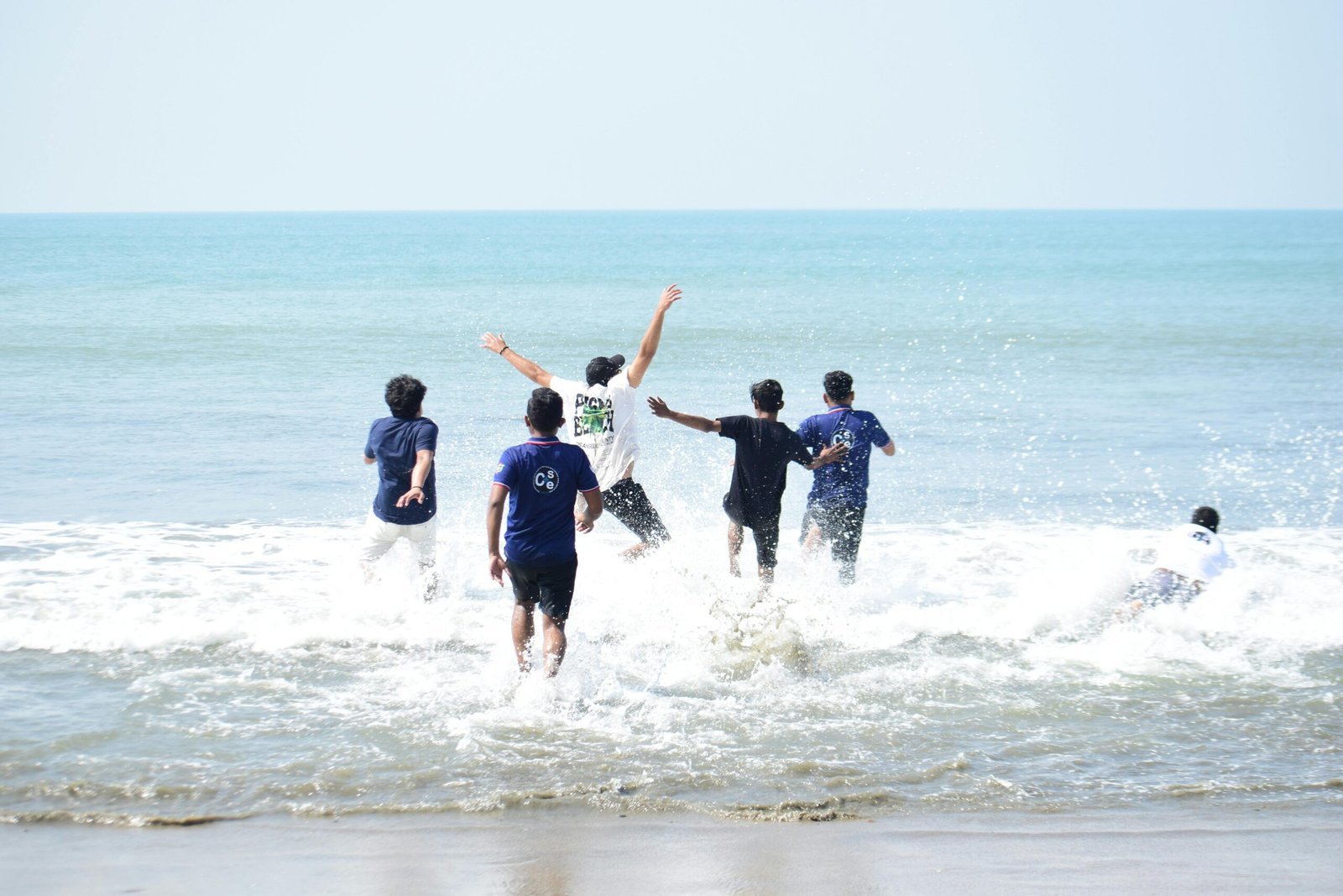 Group of friends playing and enjoying a sunny day at Cox's Bazar beach, Bangladesh.