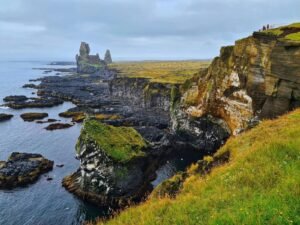 Stunning view of rocky Icelandic coastal cliffs and the sea under an overcast sky, ideal for nature lovers.