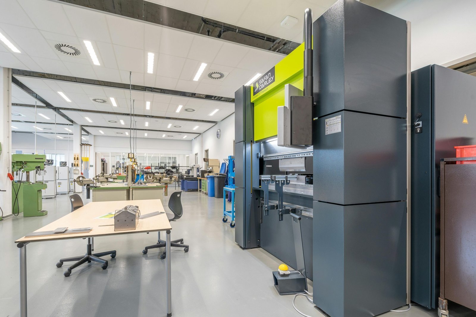 Spacious industrial workshop featuring advanced machinery and organized workstations.