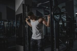 Athletic man in activewear lifting weights at the gym, showcasing strength.