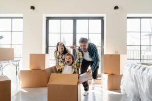 Happy family enjoying a new home moving day, with boxes and laughter.