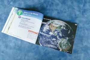 An open educational book displaying a world map and lesson outcomes about global locations.