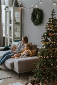 A warm family moment with mother and daughter reading by a Christmas tree.