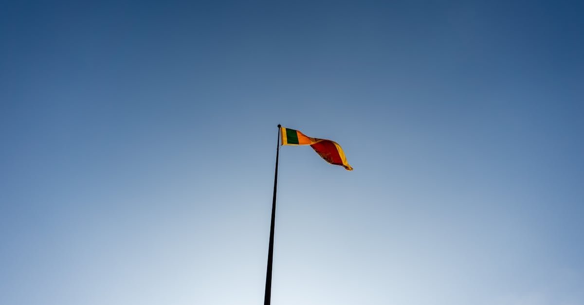 A majestic view of the Sri Lankan flag waving against a clear blue sky in Colombo.