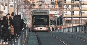 A metro tram traveling on the Ponte Luís I Bridge in Porto, Portugal, surrounded by urban architecture.
