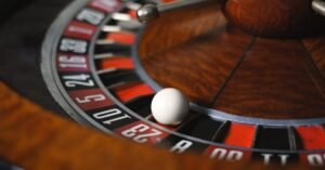 Detailed close-up image of roulette wheel highlighting numbers and spinning ball in a casino setting.