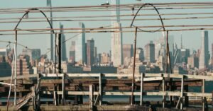 A rustic pier foreground with the vibrant New York City skyline in the background.
