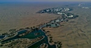 Breathtaking aerial view of the scenic Al Qudra Lake in Dubai at sunset, with winding waterways.