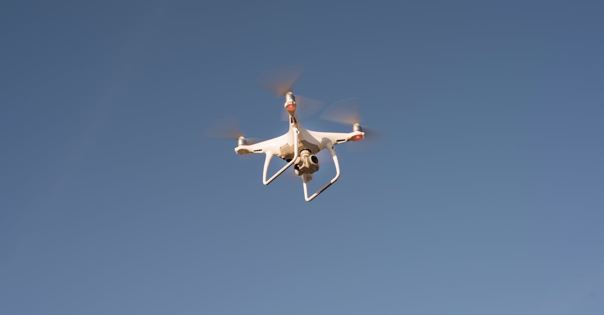 Capture of a white drone flying against a clear blue sky, showcasing modern technology.