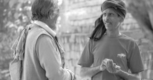 Two men engaging in a candid conversation on a rural street in Patna, India.