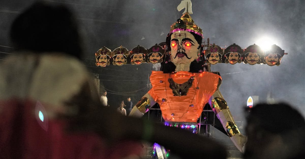 A dramatic nighttime Dussehra festival scene featuring a large illuminated Ravana effigy.