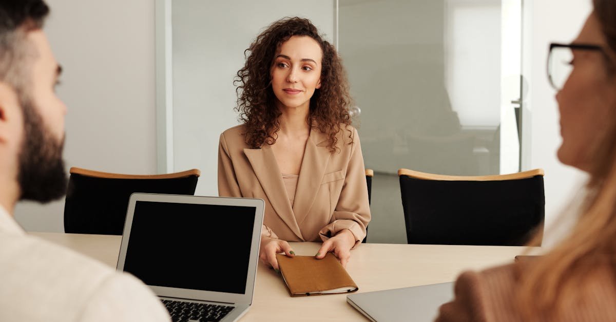 A woman in a business suit participates in a job interview, showcasing professionalism and modern office environment.