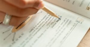 Close-up of a woman writing notes in a textbook, focusing on education and learning.