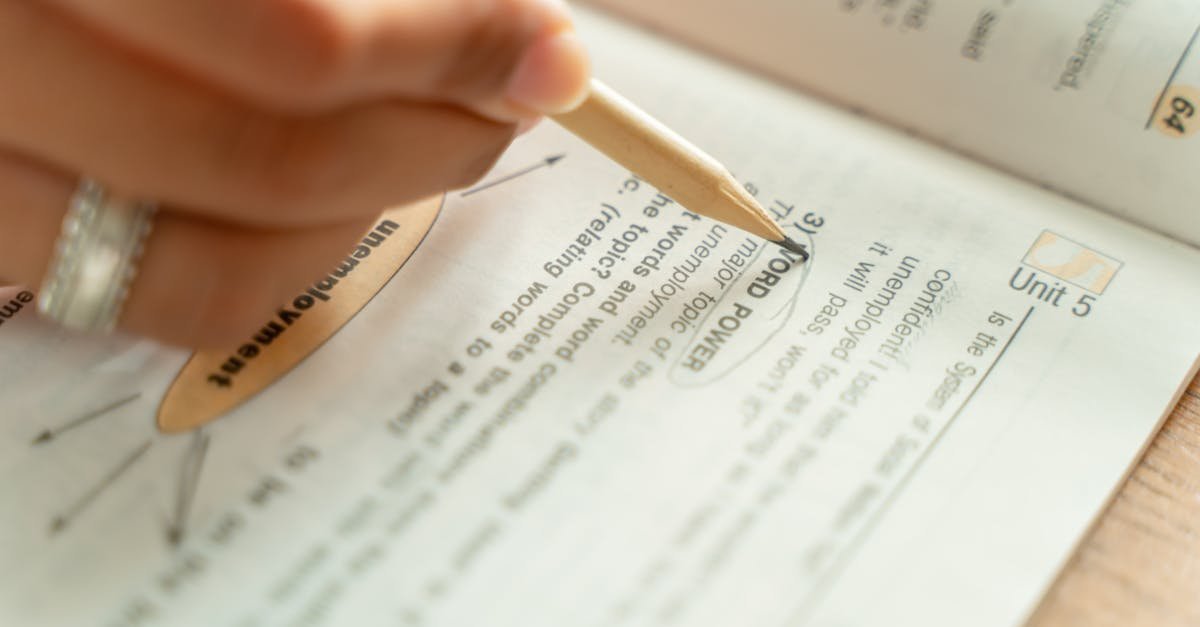 Close-up of a woman writing notes in a textbook, focusing on education and learning.
