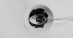 Unique black and white photo of keyboard keys in a bowl with a spoon featuring the 'Pause' key.