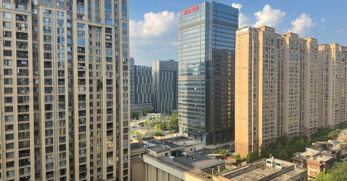 Aerial view of high-rise buildings in a modern urban cityscape under a clear blue sky.